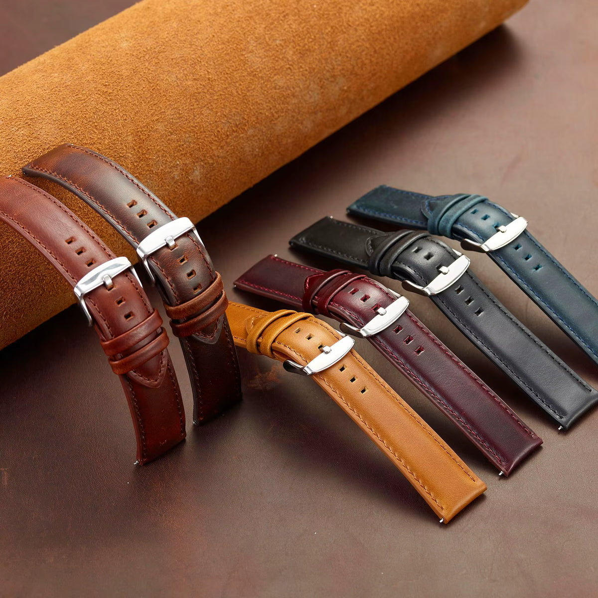 Set of leather watch straps in various colors on a brown surface